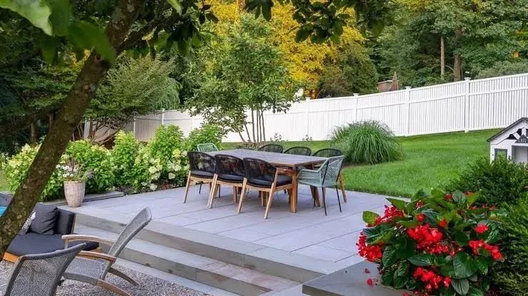A level paved patio with dining space in a back garden